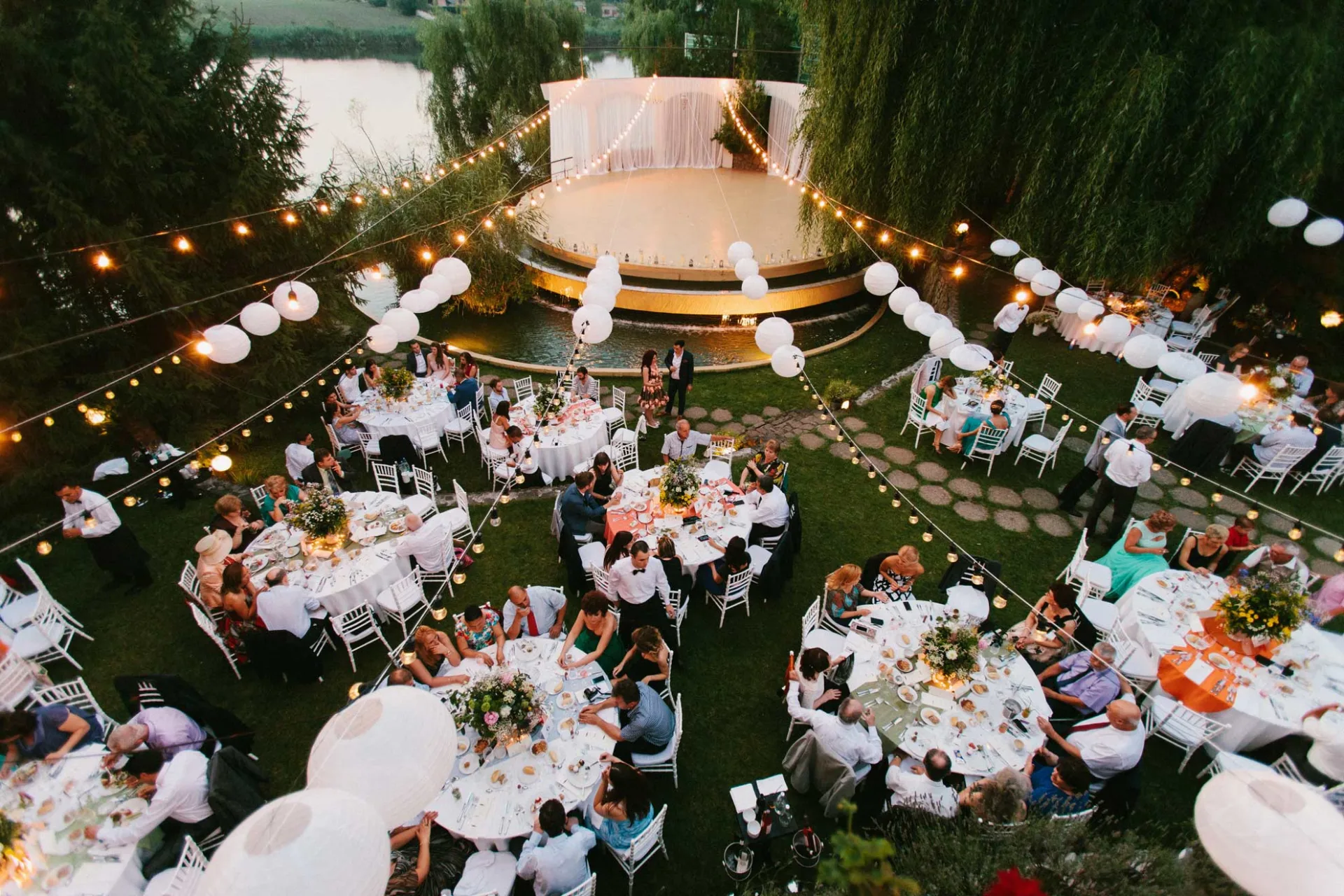 Nuntă de seară în grădina Cortina Garden, cu pontonul luminat pe lac